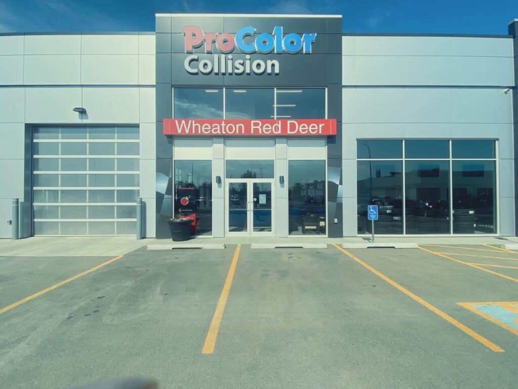 Front view of ProColor Collision Wheaton Red Deer building with parking lot.