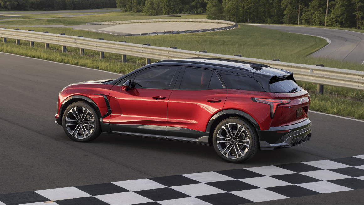 Front seat and backseat of a car with red leather upholstery and subdued lighting.