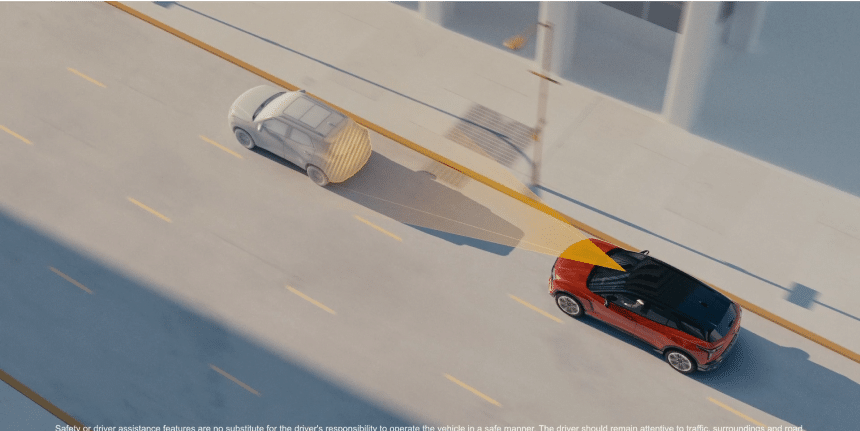 Red car demonstrating a backup sensor system on an urban street with sensor beams shown.